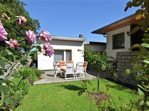 a house with chairs and a table in the yard at Attractive Bungalow in Ilsenburg with Private Terrace in Ilsenburg
