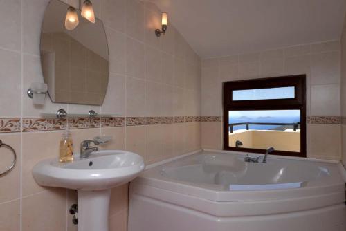 a bathroom with a sink and a tub and a mirror at Villa Gwendoline in Kalkan