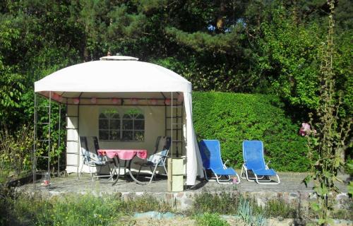 a gazebo with chairs and a table in it at Ferienhaus Bildt in Kolpinsee