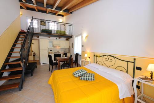 a bedroom with a yellow bed and a staircase at Agriturismo Terra E Sole in SantʼAmbrogio di Valpolicella