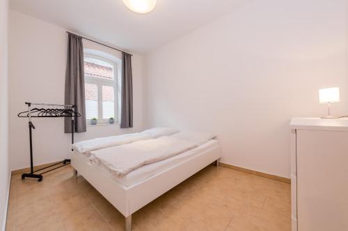 a white room with a bed and a window at Leer Innenstadt 1 in Leer