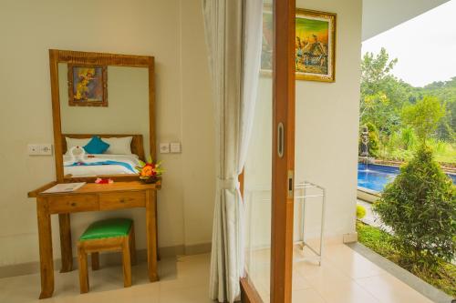 a bedroom with a desk and a mirror and a bed at The Carik Bisma Ubud in Ubud