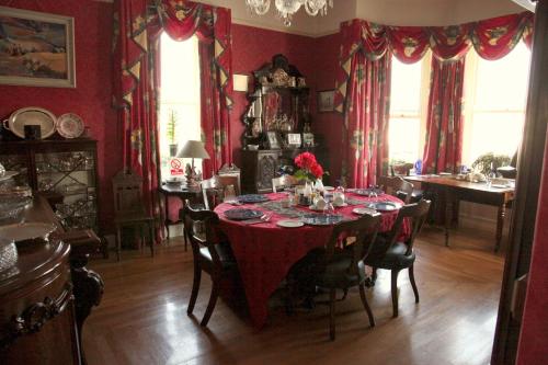 a dining room with a table with a red table cloth at Roscaoin House in Westport
