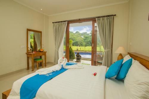 a bedroom with a bed with a stuffed animal on it at The Carik Bisma Ubud in Ubud