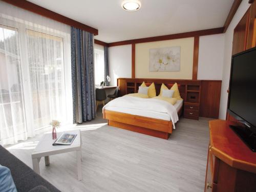 ein Hotelzimmer mit einem Bett und einem TV in der Unterkunft Pension Christiane in Sankt Kanzian am Klopeiner See