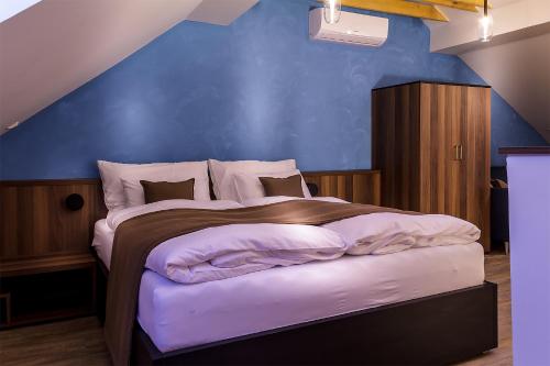 a bedroom with a large bed with a blue wall at Hnízdo in Mikulov