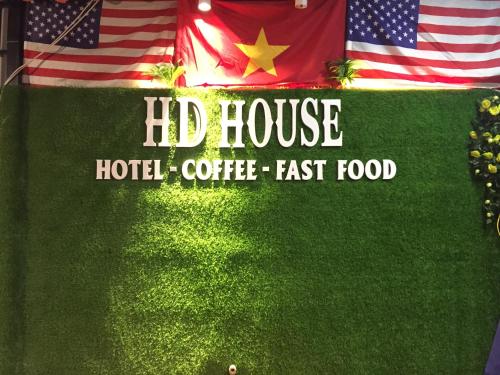 a sign for a hilt house hotel with two flags at HD Hotel Nội Bài in Noi Bai