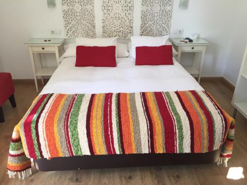 a bedroom with a bed with red pillows and two tables at Hostal Boutique Los Geranios del Pinar in Torremolinos