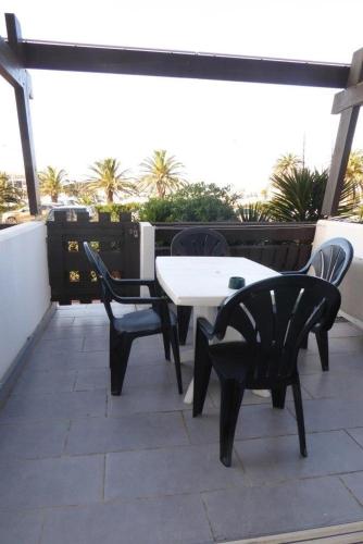 阿格德角的住宿－Cap Agde Village naturiste Port Nature，屋顶上配有白色桌椅的庭院