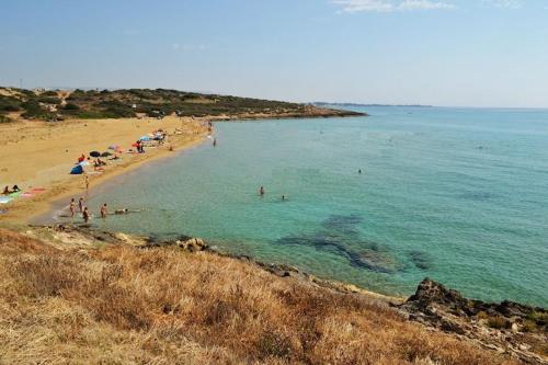 a group of people on a beach in the water at Casa Bedda in Noto Marina