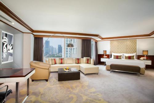 a large hotel room with a bed and a couch at Wyndham Casablanca Jakarta in Jakarta