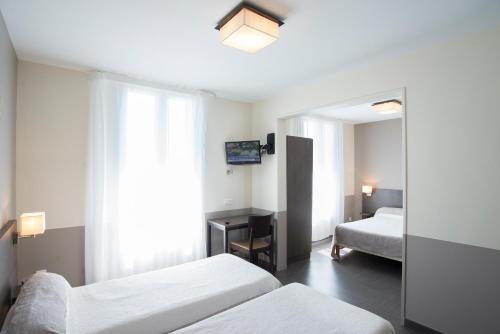 um quarto de hotel com duas camas e um espelho em HOTEL RESTAURANT LES STALAGMITES em Orgnac-lʼAven