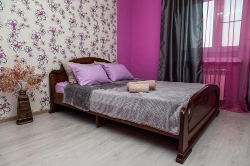 a bedroom with a bed with purple walls at Apartment on Kukolkina in Voronezh
