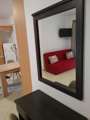 a mirror reflecting a red couch in a living room at Spyros Studio in Nafplio
