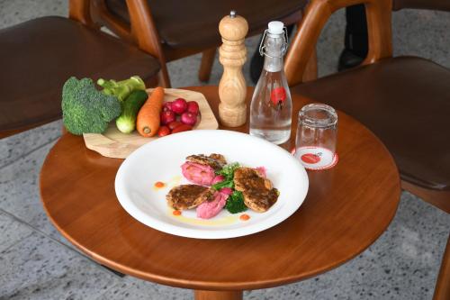 a plate of food on a table with vegetables at Paralian Hulhumale' in Hulhumale