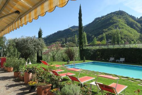 a pool with chairs and a mountain in the background at Garni Hotel Burgleitenhof in Lana