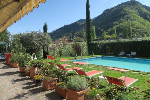 a row of chairs next to a swimming pool at Garni Hotel Burgleitenhof in Lana