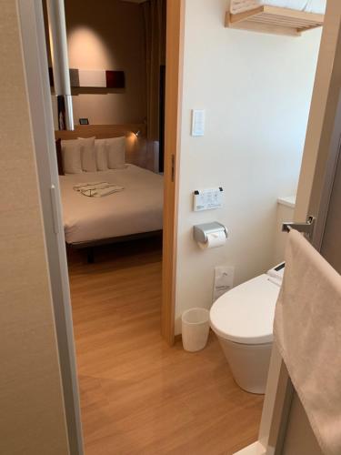 大阪市にあるレッドルーフイン＆スイーツ大阪難波・日本橋のバスルーム(トイレ付)、ベッド1台が備わります。