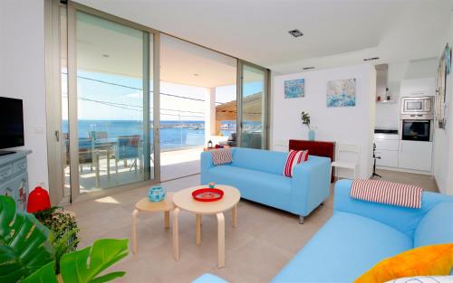 sala de estar con sofá azul y mesa en Apartamento s' Estanyol Mar en El Estanyol