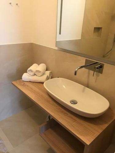 a bathroom with a sink and towels on a counter at Garni Hotel Burgleitenhof in Lana