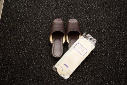 a pair of shoes and a bag on a table at Sanco Inn Yokkaichi Ekimae in Yokkaichi
