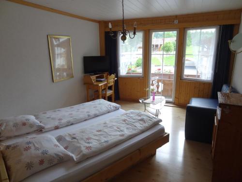a bedroom with a bed and a living room at Chalet Hotel Adler in Kandersteg
