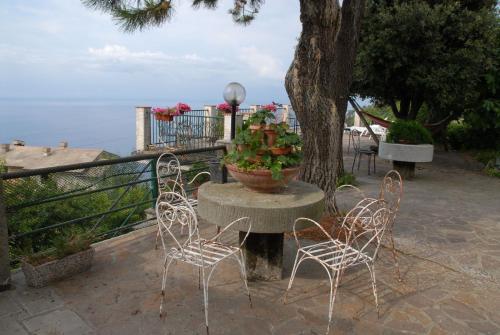 a group of chairs and a table with a pot of flowers at La Foce Del Prato in Framura