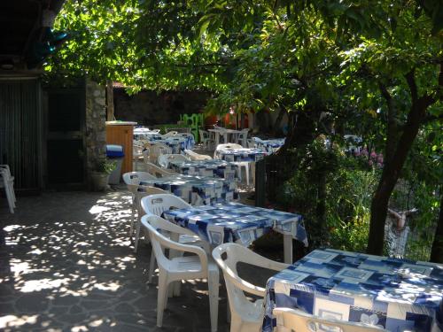 a row of tables and chairs with blue and white table cloth at La Foce Del Prato in Framura