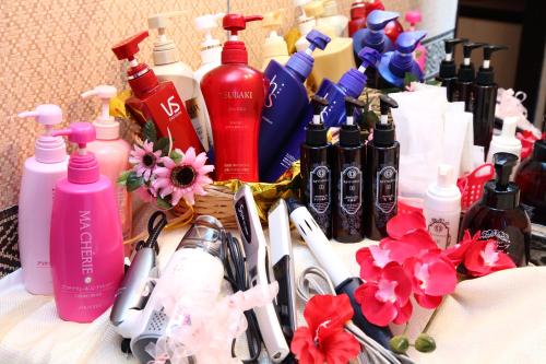 un montón de botellas de productos para el cabello y flores en Santa no Ouchi-LoveHotel, en Miyazaki