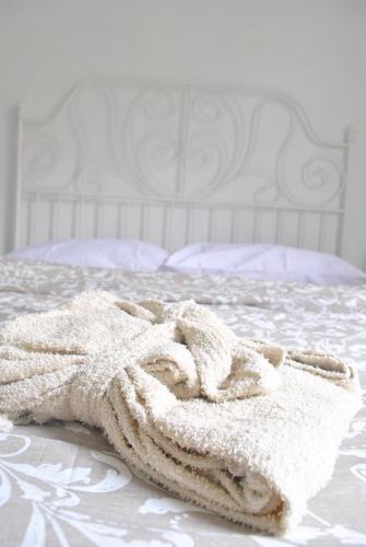 a white blanket sitting on top of a bed at Sunrise Hostel & Rooms in Palermo
