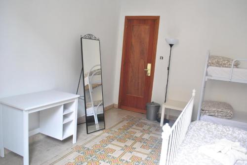 a room with a door and a mirror and a bed at Sunrise Hostel & Rooms in Palermo