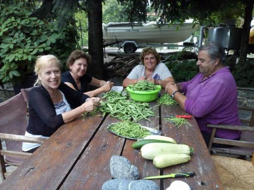 a group of people sitting at a table with vegetables at Dimosthenis Karastamatis Rooms in Xorychti