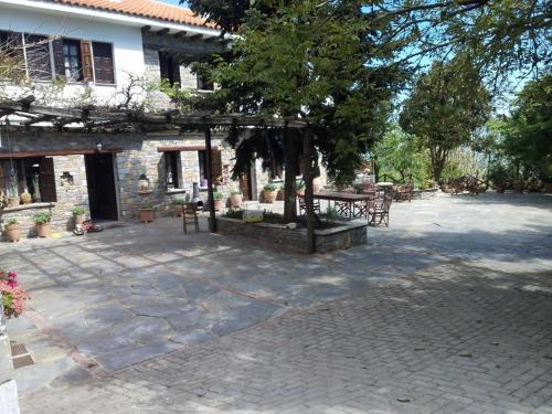 a patio with a table and chairs in front of a building at Dimosthenis Karastamatis Rooms in Xorychti