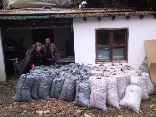 a man and a woman standing in front of a pile of bags at Dimosthenis Karastamatis Rooms in Xorychti