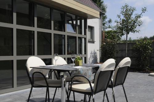 a dining table with white chairs and a table and chairsktop at Gastenhof Ter Lombeek in Onze-Lieve-Vrouw-Lombeek