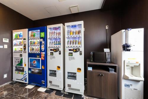 four soda machines are lined up against a wall at Sanco Inn Yokkaichi Ekimae in Yokkaichi