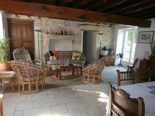 a living room with chairs and a table and a fireplace at La Parisienne des Amognes in Montigny-aux-Amognes