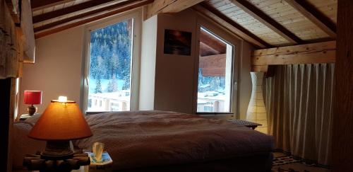 a bedroom with a bed and a large window at B&B St Moritz in St. Moritz