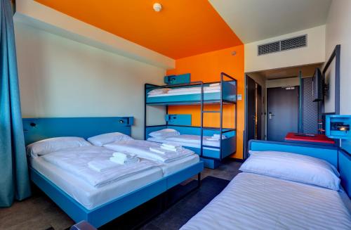 two bunk beds in a room with an orange ceiling at MEININGER Budapest Great Market Hall in Budapest