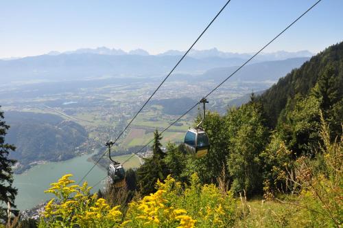 a couple of people riding a gondola on a mountain at Gästehaus Trink B&B in Drobollach am Faakersee