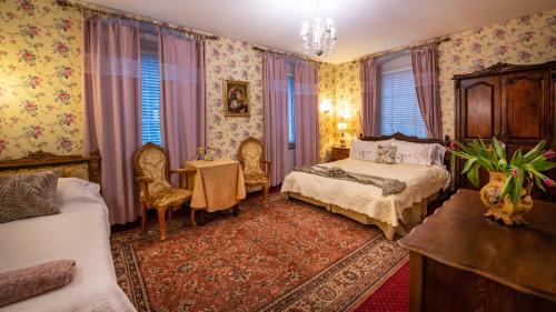 a bedroom with two beds and a table and chairs at Rezydencja Grawert Boutique & Spa in Lądek-Zdrój