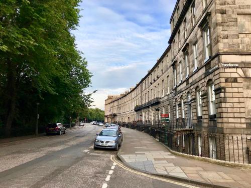 un coche aparcado en una calle al lado de un edificio en Escape to Edinburgh @ Abercromby Place, en Edimburgo