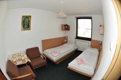 Habitación pequeña con cama, mesa y sillas en Penzión Váh, en Liptovská Teplička