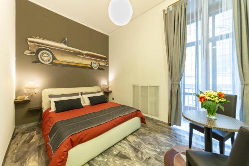 - une chambre avec un lit et une voiture sur le mur dans l'établissement Il Ventre di Napoli "Broggia", à Naples
