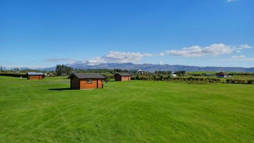 a large green field with small buildings in it at Hellisholar Cottages in Hellisholar