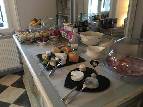 a buffet with many different types of food on a counter at O Mylle Douceurs in Le Crotoy