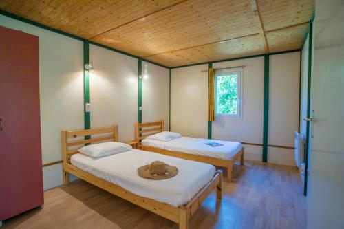 Кровать или кровати в номере Bungalows & Rooms - Gît'Ôstal