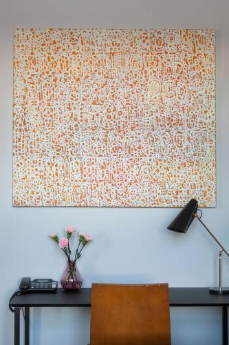 a table with a vase of flowers on a wall at Hotel Lasaretti in Oulu