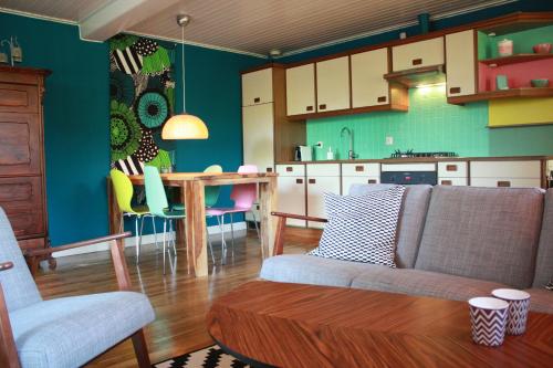 een woonkamer en een keuken met een bank en een tafel bij BnB De Peelvos in Deurne