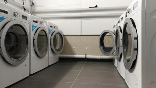 a row of washing machines in a laundry room at Myroom Business Apartment Nähe Messe München in Munich